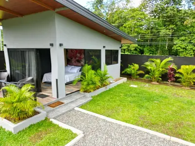 a small house with a bedroom and a garden at Casitas del Arenal in Fortuna