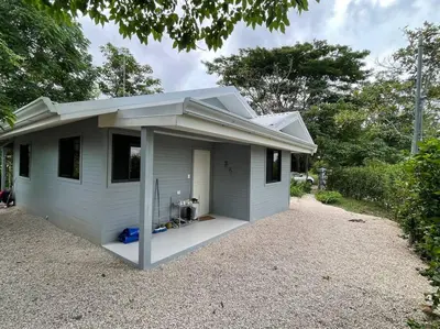 a small white house with a porch on a gravel driveway at Casa Lupa in San Rafael