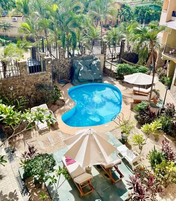 an overhead view of a swimming pool with chairs and an umbrella at Pipas Apartment in Tamarindo
