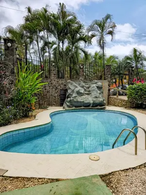 a swimming pool with a waterfall in a yard at Pipas Apartment in Tamarindo