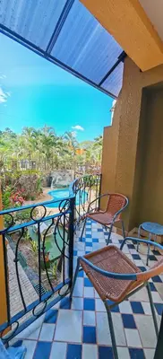 a patio with chairs and tables on a balcony at Pipas Apartment in Tamarindo