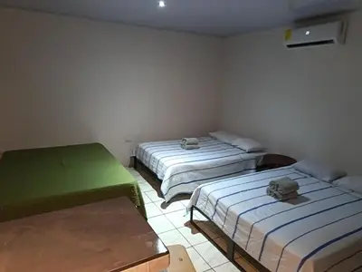 a room with two beds in a room at Villa Granja Agua Azul-wi-fi-AC-6 Personas-parqueo in Agua Azul