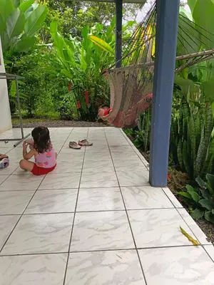 a little girl sitting on the floor of a patio at Villa Granja Agua Azul-wi-fi-AC-6 Personas-parqueo in Agua Azul