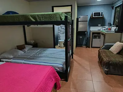 a bedroom with a bunk bed and a kitchen at Apartment-Pura Vida-Wi-Fi-TV-WC-AC-Parqueo in Fortuna