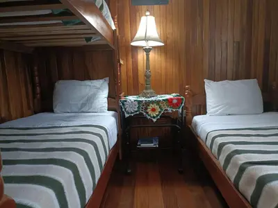 a small room with two beds and a lamp at Hotel Bell Bird in Monteverde Costa Rica
