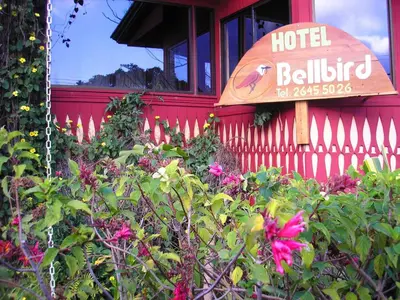 a hotel building with a sign and flowers at Hotel Bell Bird in Monteverde Costa Rica