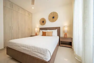 a bedroom with a large bed and two mirrors on the wall at La Vista B8 in Tamarindo
