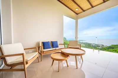 a living room with a table and chairs and a large window at La Vista B8 in Tamarindo