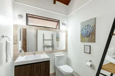 a white bathroom with a toilet and a sink at Angels Sol Villa Hermosa 2b2b European Villa in Playa Hermosa