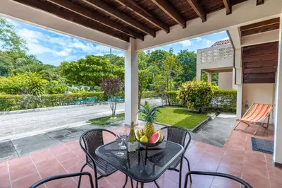 a patio with a table and chairs and a large window at Angels Sol Villa Hermosa 2b2b European Villa in Playa Hermosa