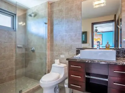 a bathroom with a toilet and a shower and a sink at Beachfront Diamante del Sol 601S in Jacó