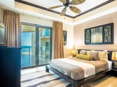 a bedroom with a bed and a large window at Beachfront Diamante del Sol 601S in Jacó