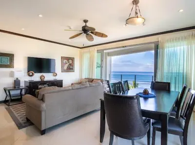 a living room with a couch and a table with chairs at Beachfront Diamante del Sol 601S in Jacó