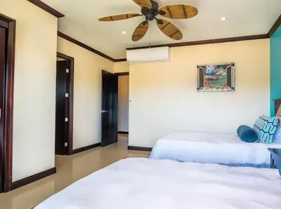 a bedroom with two beds and a ceiling fan at Beachfront Diamante del Sol 601S in Jacó