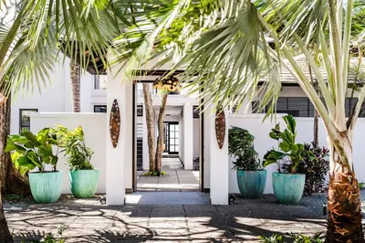 a hallway with palm trees in front of a building at The Point Luxury Villa, Tamarindo in Tamarindo