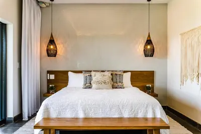 a bedroom with a large white bed with two lights at The Point Luxury Villa, Tamarindo in Tamarindo