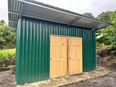 a green and wooden shed with two doors at Camping El Fosforo in El Fosforo
