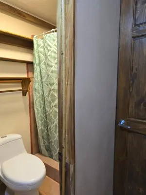 a bathroom with a toilet and a shower curtain at Cool Waters Jungle Hostel in Uvita