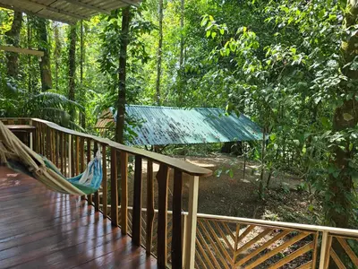 a hammock on a deck in the woods at Cool Waters Jungle Hostel in Uvita