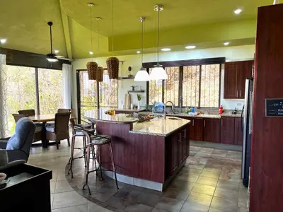 a kitchen with a island in the middle of a room at Casa del Artista 4bed,4 bath Ocean view home in Playa Hermosa
