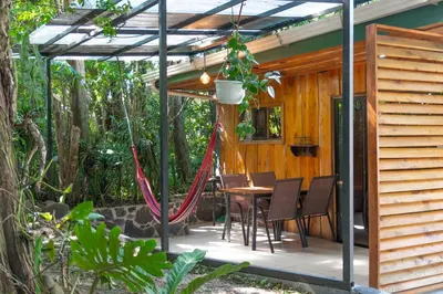 a patio with a table and chairs under a pergola at Villa Tabacon in Monteverde Costa Rica