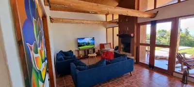 a living room with blue couches and a television at Peaceful Mountain Experience - Coyote House in Poás