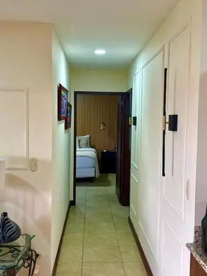 a hallway of a hotel room with a bed at Palmas de Tamarindo Resort, 304E in Guanacaste