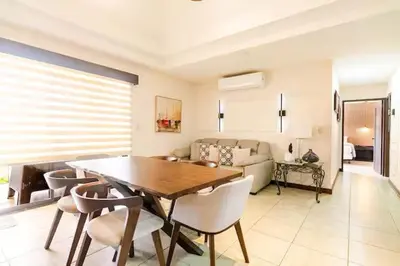 a living room with a wooden table and chairs at Palmas de Tamarindo Resort, 304E in Guanacaste
