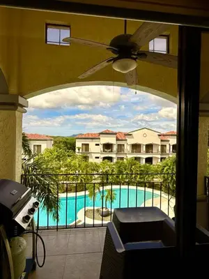 a balcony with a view of a pool and a building at Palmas de Tamarindo Resort, 304E in Guanacaste