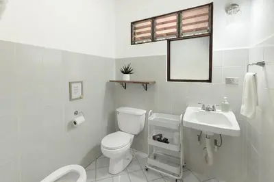 a white bathroom with a toilet and a sink at Angels Mar Villa Hermosa 2b2b European Villa in Playa Hermosa