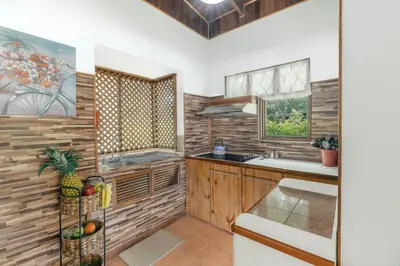 a kitchen with wooden cabinets and a sink and a window at Angels Mar Villa Hermosa 2b2b European Villa in Playa Hermosa