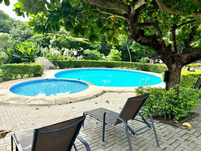 a swimming pool with two chairs and a tree at Angels Mar Villa Hermosa 2b2b European Villa in Playa Hermosa