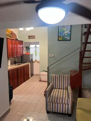 a living room with a couch and a kitchen at Enchanting 3 BR 2 Bath Condo in the Heart of Jaco in Jacó