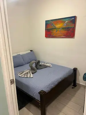 a bed in a room with a painting on the wall at Enchanting 3 BR 2 Bath Condo in the Heart of Jaco in Jacó