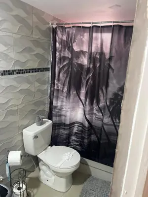 a bathroom with a toilet and a shower curtain at Enchanting 3 BR 2 Bath Condo in the Heart of Jaco in Jacó