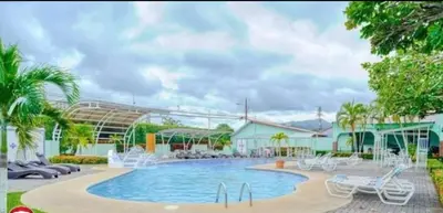 a swimming pool with chairs and a resort at Enchanting 3 BR 2 Bath Condo in the Heart of Jaco in Jacó