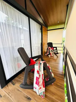 a room with a chair and a large window at Cabañas La Hermosa #2 in Guápiles