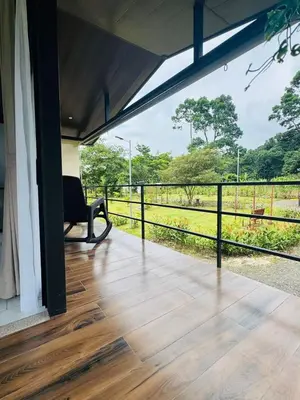 a porch with a chair and a view of a field at Cabañas La Hermosa #2 in Guápiles