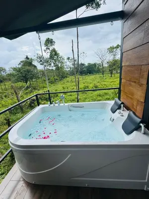 a bath tub with a view of a field at Cabañas La Hermosa #2 in Guápiles