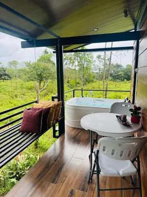 a room with a tub and a table and chairs at Cabañas La Hermosa #2 in Guápiles