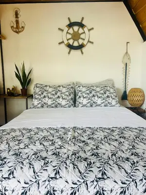 a bedroom with a bed with a nautical sign on the wall at Hotel en Huacas y Brasilito in Matapalo