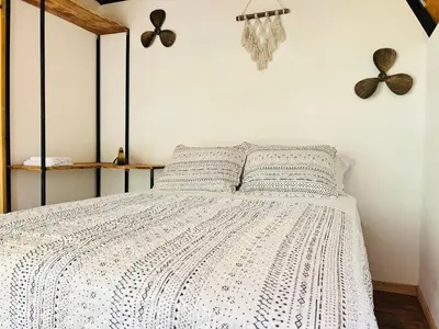 a bedroom with a bed with a black and white comforter at Hotel en Huacas y Brasilito in Matapalo