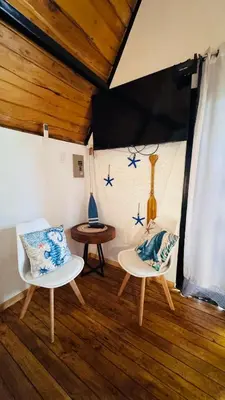 two white chairs and a table in a room at Hotel en Huacas y Brasilito in Matapalo