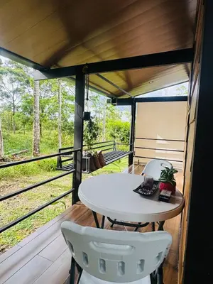 a room with a table and two chairs on a porch at Cabañas La Hermosa #1 in Guápiles