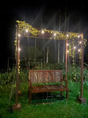 a wooden bench under a pergola with lights at Cabañas La Hermosa #1 in Guápiles