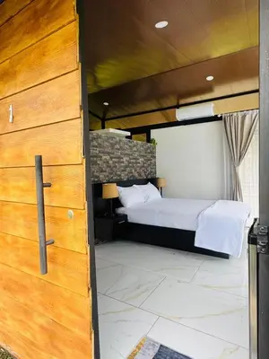 a bedroom with a bed and a large wooden door at Cabañas La Hermosa #1 in Guápiles