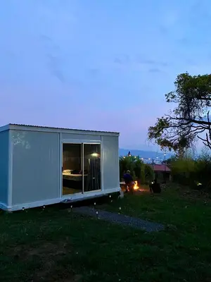 a small white building in a field with a tree at Cedro lodge in Fraijanes