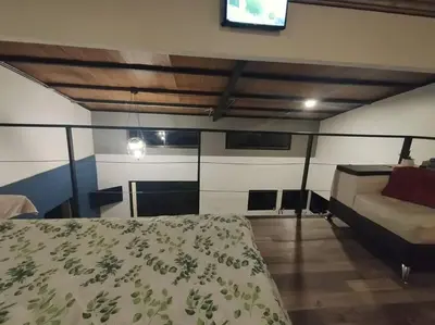 a bedroom with a bed and a flat screen tv at Tiny Bosque del Barro in Barrio Jesús