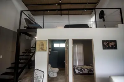 a room with a loft bed and a toilet at Tiny Bosque del Barro in Barrio Jesús