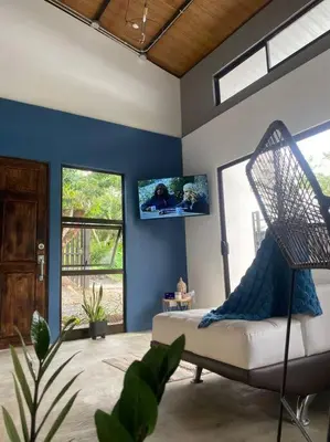 a living room with a couch and a tv on the wall at Tiny Bosque del Barro in Barrio Jesús